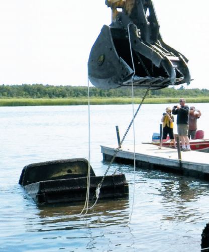 excavator pulling truck from rainy river