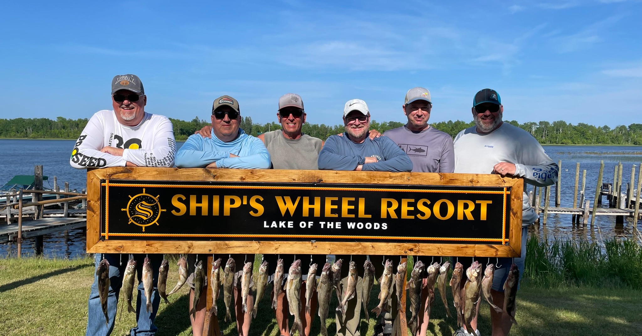 Guys-with-walleyes-at-Ships-Wheel-Resort-sign-on-the-Rainy-River