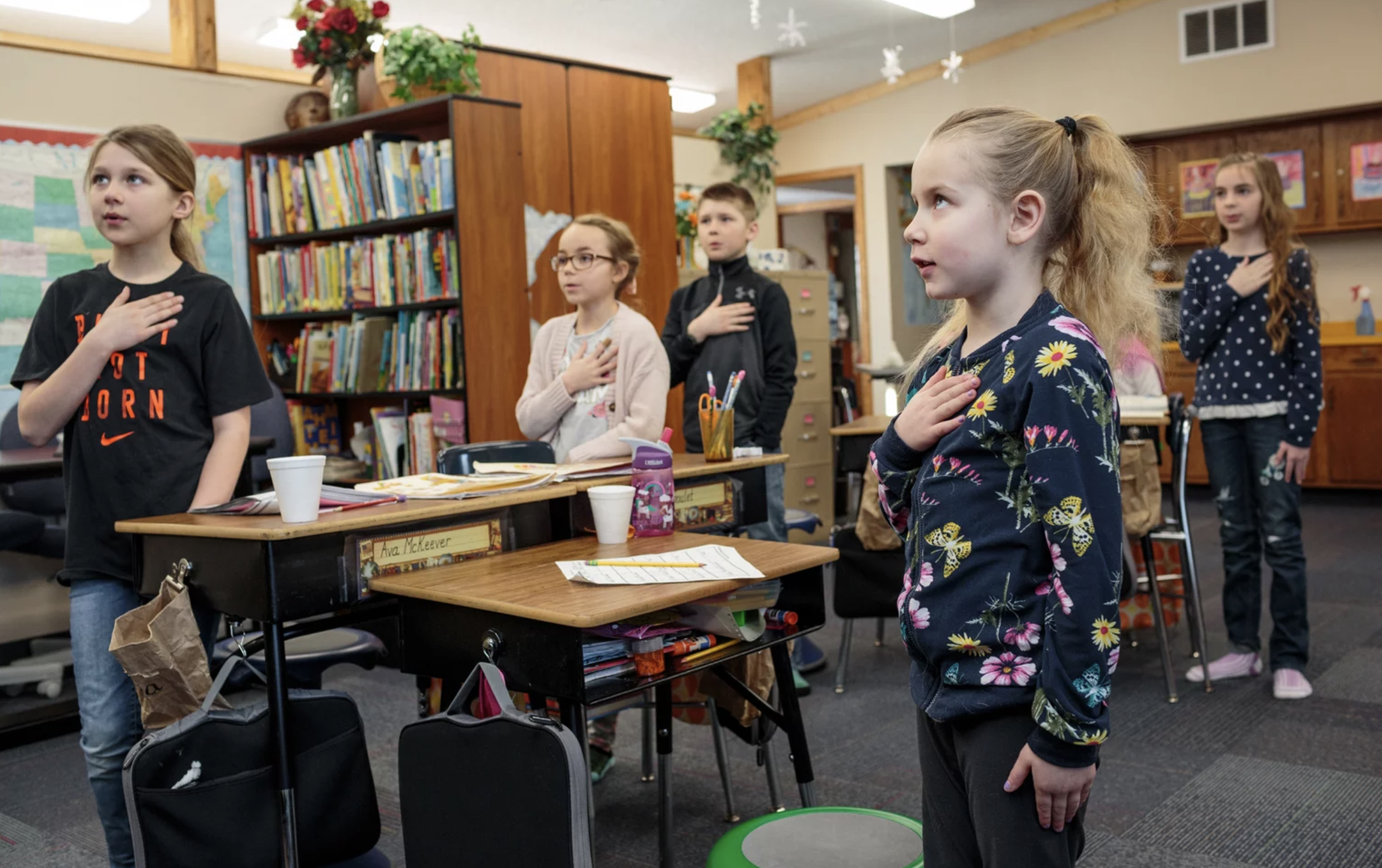 Students recite the Pledge of Allegiance at the Angle Inlet School