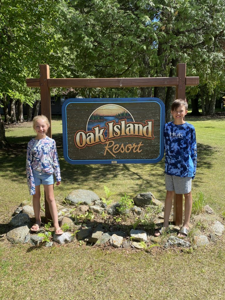 Oak Island Resort sign with two boys
