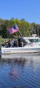 Veterans on charter boat with flag, Pay It Forward