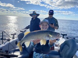 Boy hoisting big walleye Arnesens Rocky Point 072224