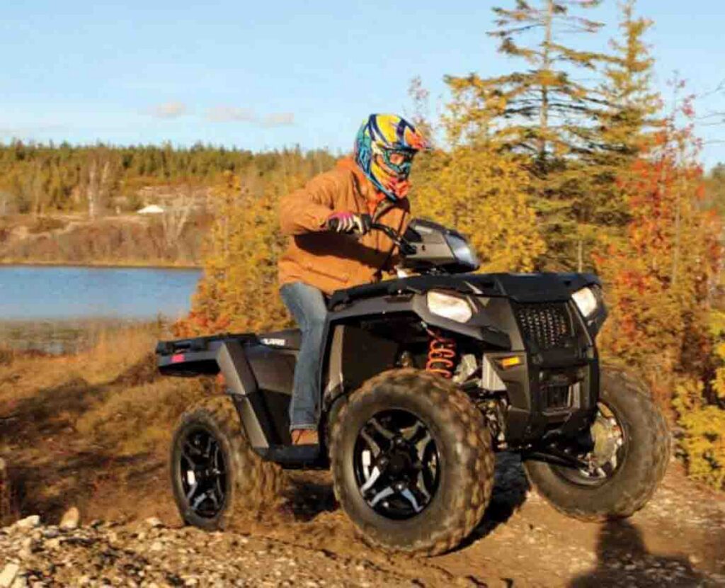 An ATV rider cruises trails on Lake of the Woods while surrounded by fall colors