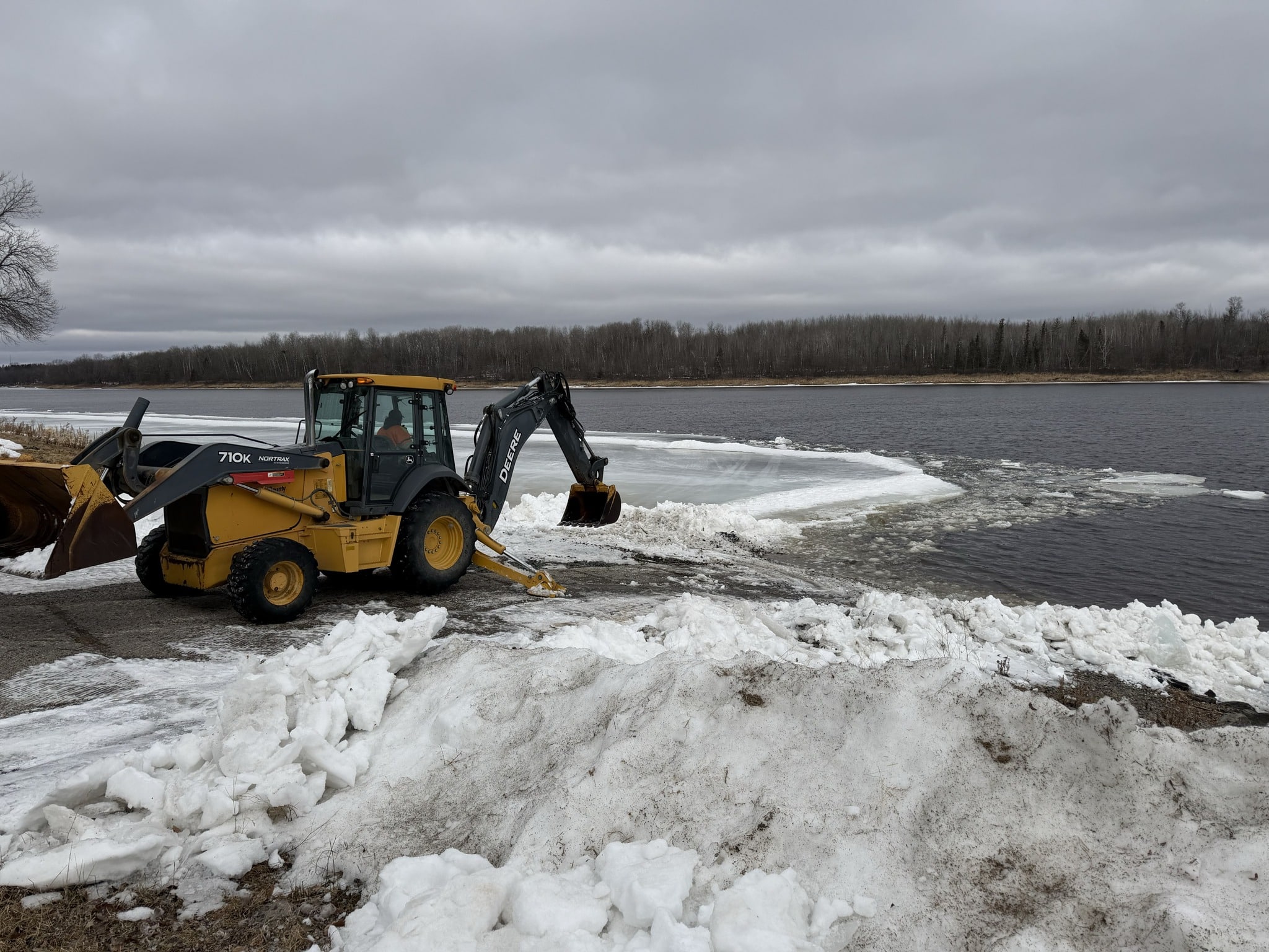 Backhoe opening up Nelson Park in Birchdale, MN on the Rainy River, spring fishing. 032626
